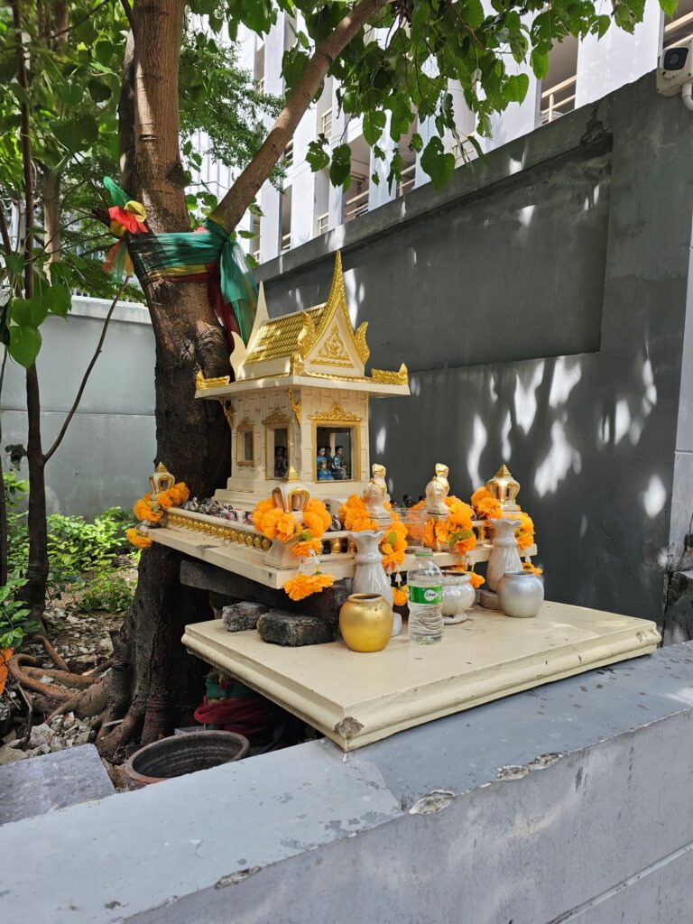 A local shrine, made of gold leaf, with numerous offerings, and laden with orange marigold flower garlands for good fortune.