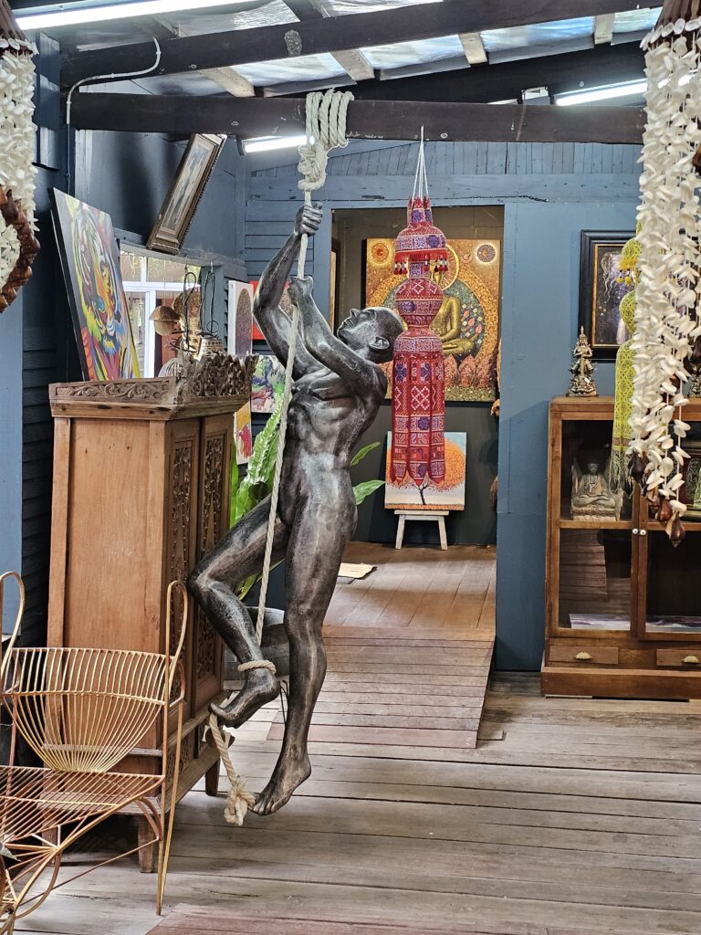 A life-size scuplture of a human female climbing a rope