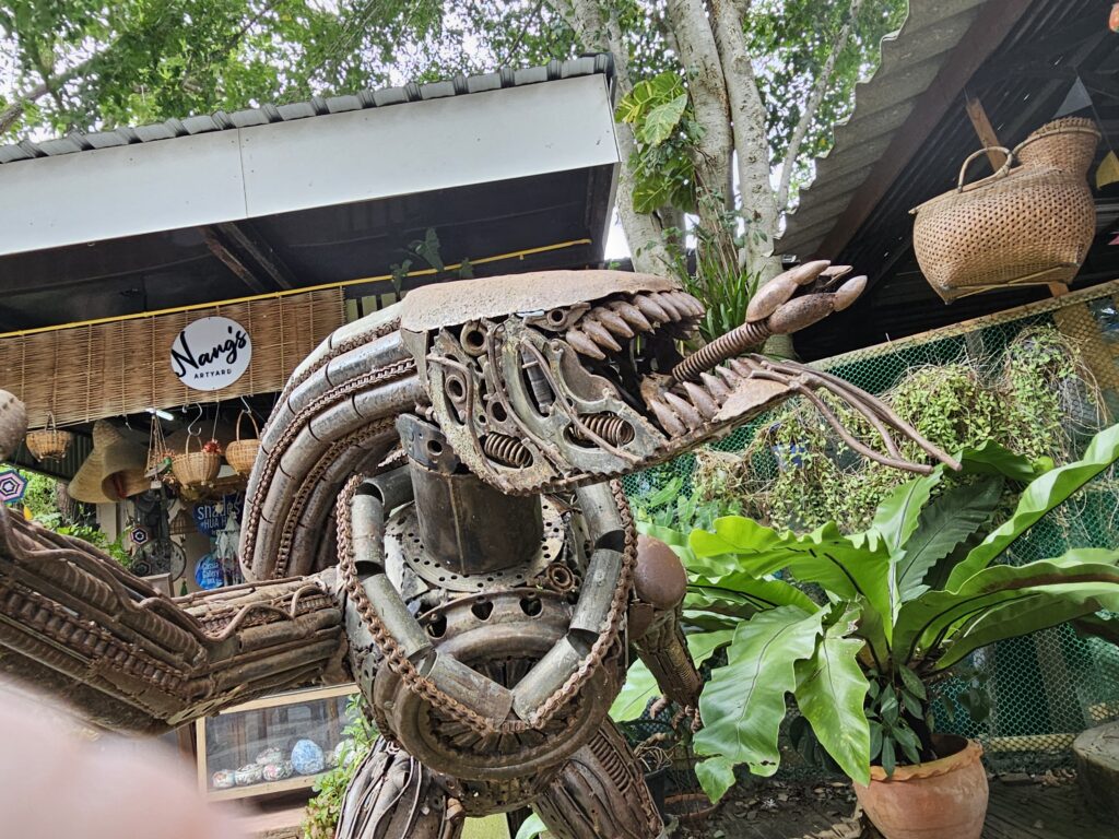 A sculpture of a xenomorph alien, made of scrap metal